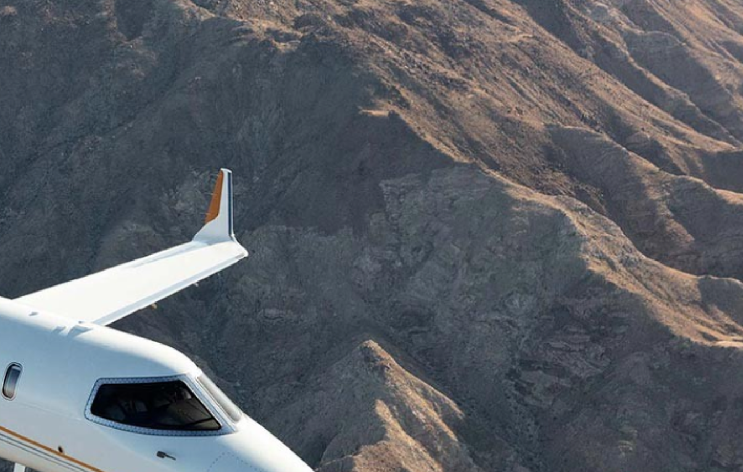 Jet flying next to mountains